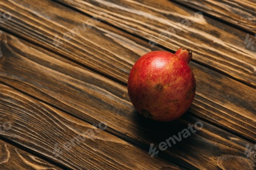 Preview: top view of ripe pomegranate on wooden surface