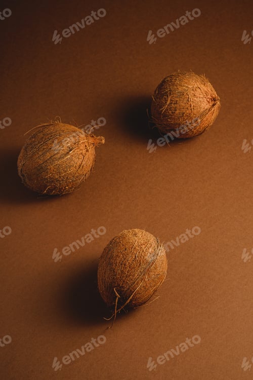 Preview: Three coconut fruits on brown background