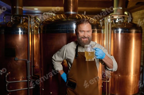 Preview: Brewery technologist tasting fresh craft beer at microbrewery plant