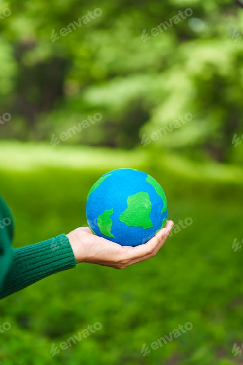 Preview: Forest conservationist holds small globe in hands,symbolizing global responsibility for protecting