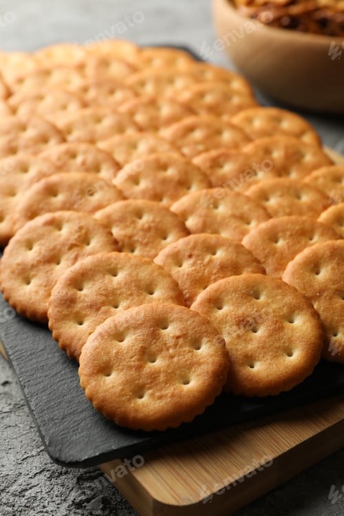 Preview: Board with cracker biscuits on gray background