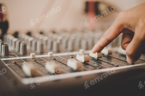 Preview: Man hands of sound engineer adjusting audio mixing console.