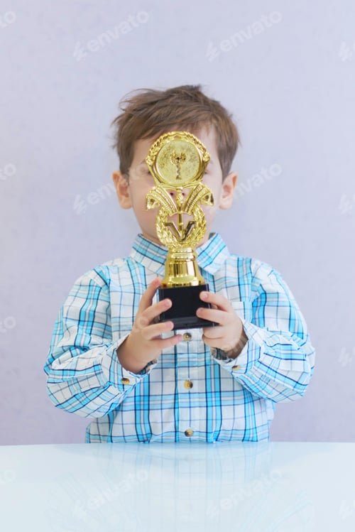 Preview: funny boy age three years old, holding in holding a trophy