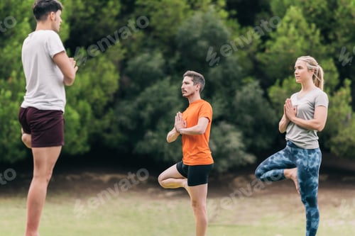 Preview: Three persons practising yoga in a park