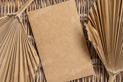 Preview: Blank card on a wattled table with dry palm leaves
