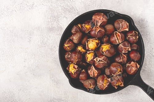 Preview: Roasted chestnuts, in an iron pan, wooden table, top view, no people, rustic style,