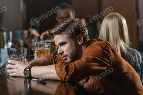 Preview: very drunk caucasian man with automobile keys at bar with friends