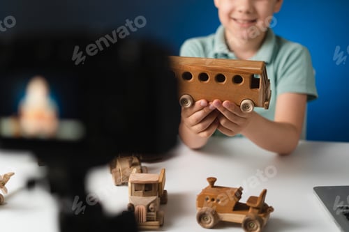 Preview: Boy holding a wooden bus in hands while streaming about it online