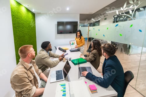 Preview: Marketing team analyzing charts during business meeting in modern office