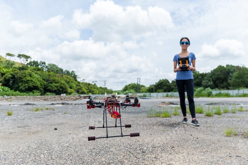 Preview: Woman controlling flying drone at outdoor