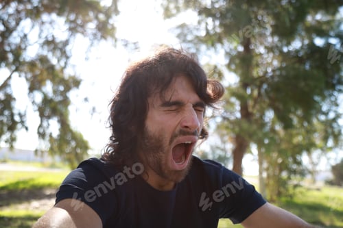 Preview: Long Hair Man Yawns Sitting In The Park After A Day At Work