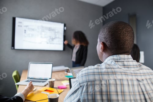 Preview: Architects discussing blueprint in office