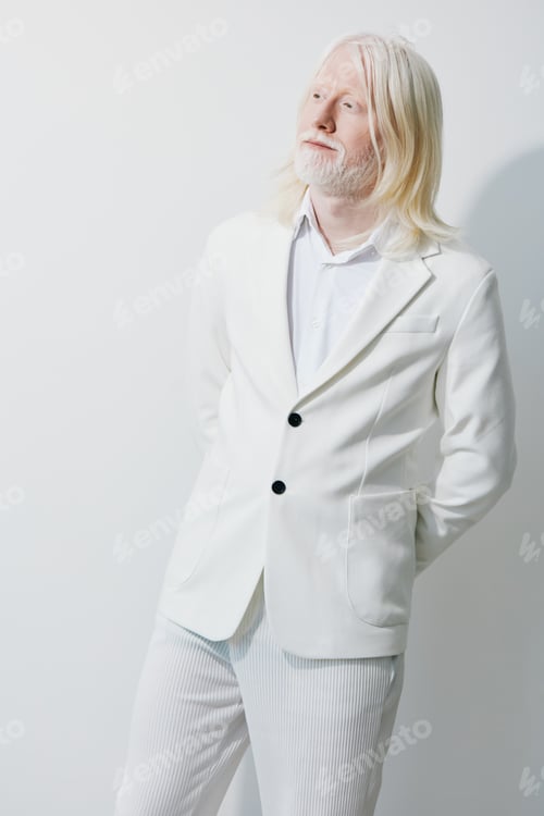 Preview: Fashionable man wearing a stylish white suit against a clean, light background, exuding elegance and