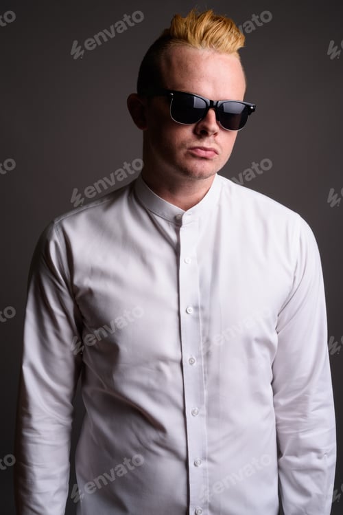 Preview: Businessman with Mohawk hairstyle and blond hair against gray ba