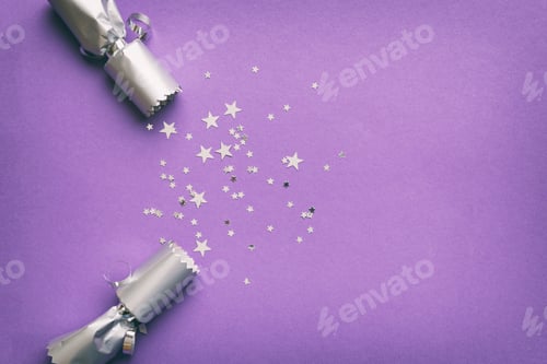 Preview: Christmas crackers with shiny confetti on color background, top view, copy space