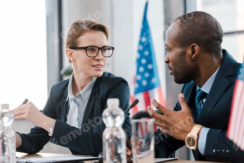 Preview: selective focus of attractive diplomat talking with african american representative