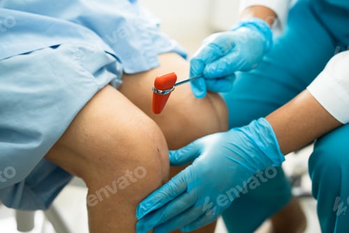 Preview: Asian doctor physiotherapist examining, massaging and treatment knee and leg of senior patient