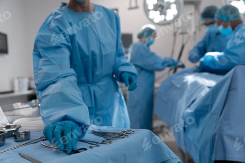 Preview: Midsection of female surgeon reaching for surgical scissors in operating theatre