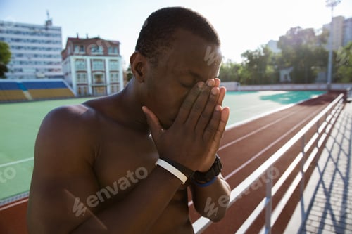 Preview: Close up of a tired african sportsman leaning on the railing