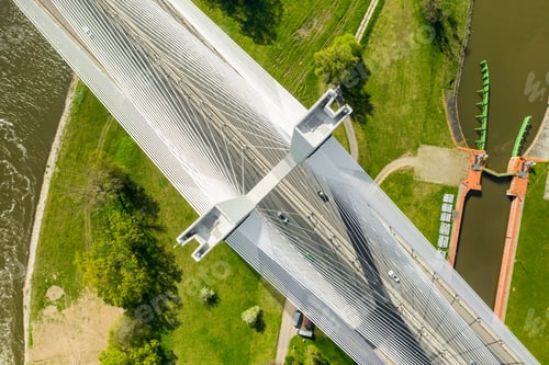 Preview: Top view of cable-stayed pylon bridge above urban parks with green grass