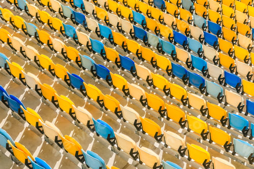 Preview: elevated view of rows of yellow and blue stadium seats background
