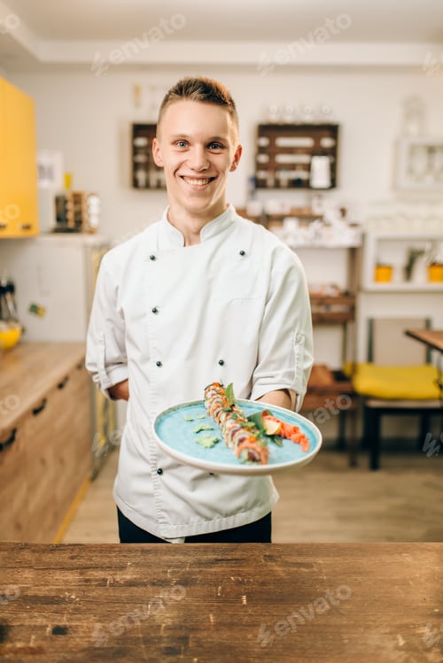 Preview: Male chef hold sushi rolls on plate, asian food