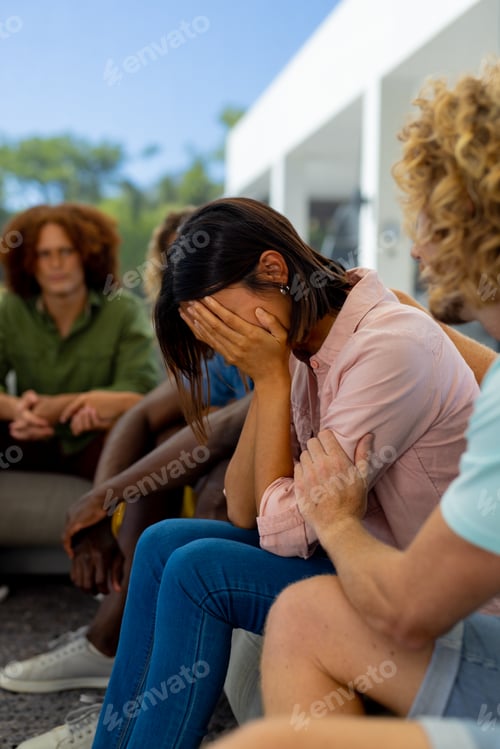 Preview: Group of diverse people sitting on sofa, talking and crying in group therapy session