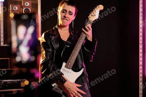 Preview: Rebel rockstar holding electric guitar playing heavy metal song recording performance with modern