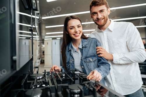 Preview: Young couple choosing new gas stove in home appliances store
