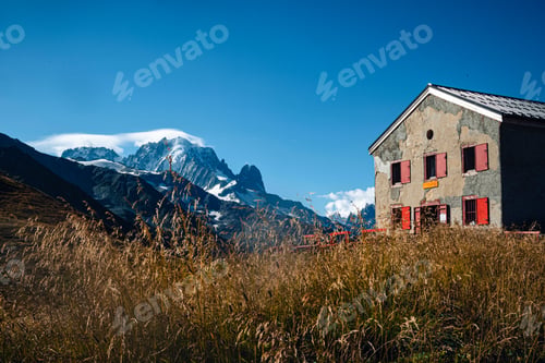 Preview: A building in the middle of mountains in the Tour Du Mont Blanc with green landscapes