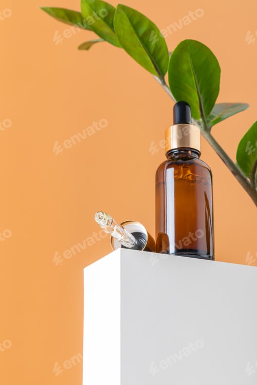 Preview: Glass cosmetic bottles with oil or serum for skin care on special podium on beiger background.