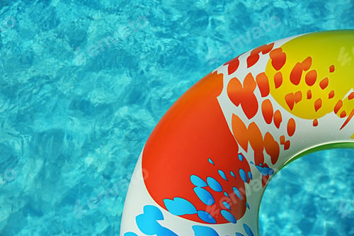 Preview: Colorful inflatable ring floating in swimming pool on sunny day, above view. Space for text