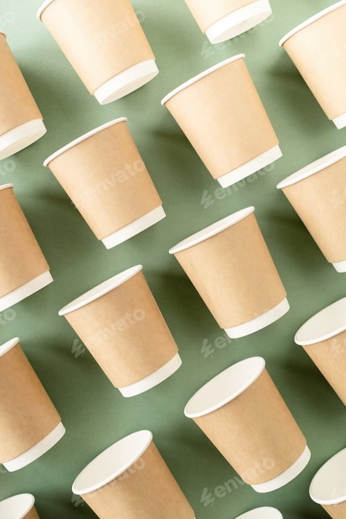 Preview: Disposable paper cups pattern top view on green background