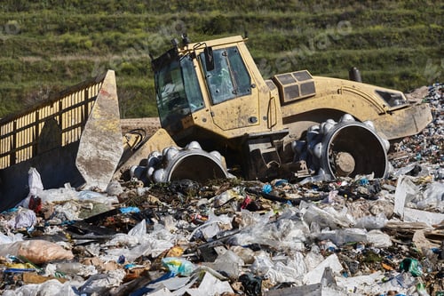Preview: Heavy machinery shredding garbage in an open air landfill. Pollution