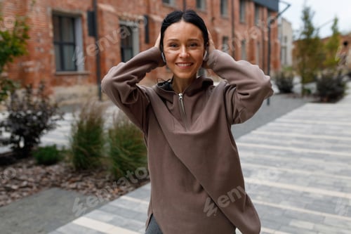 Preview: Sporty woman in headphones posing on the street