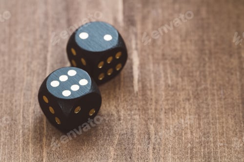 Preview: Close-up of black dice on a wooden table
