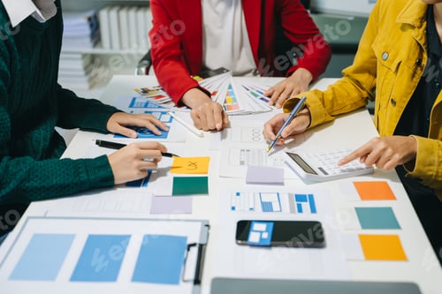 Preview: Close up view of UI developer team brainstorming on their project with laptop, smartphone