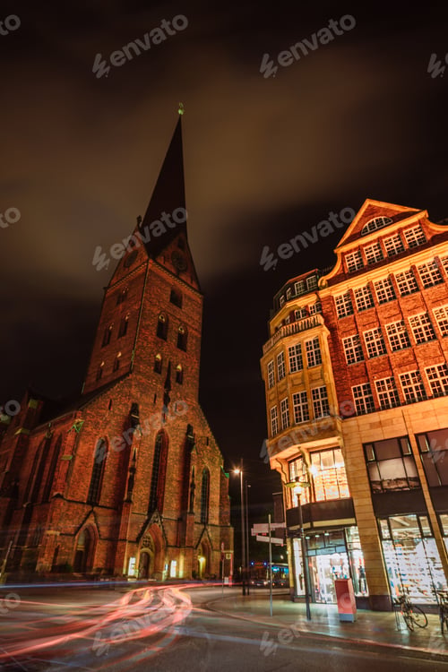 Preview: City view of Hamburg downtown at night. View of St. Petri church and traditional red brick buildings