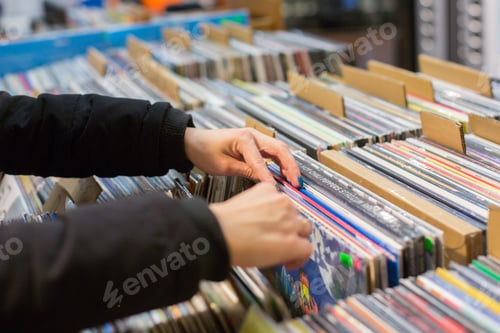 Preview: Young woman music lover chooses records with music in the store.