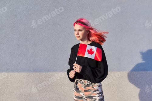 Preview: Student girl teenager with Canada flag in hand, gray outdoor wall background