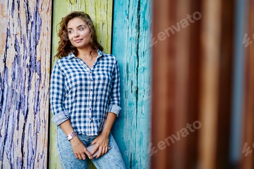 Preview: Woman in Blue Plaid Shirt Leaning on Wall