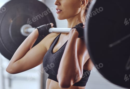 Preview: Seriously strong. Shot of a young woman working out with weights at the gym.