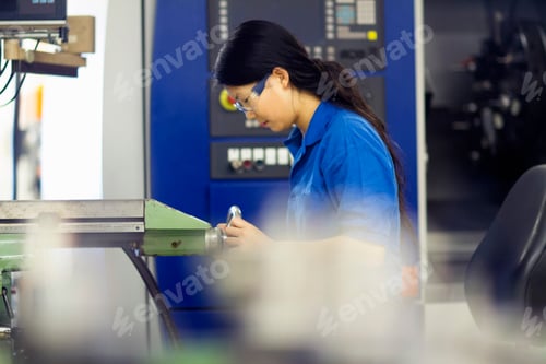 Preview: Young woman working in industrial workshop