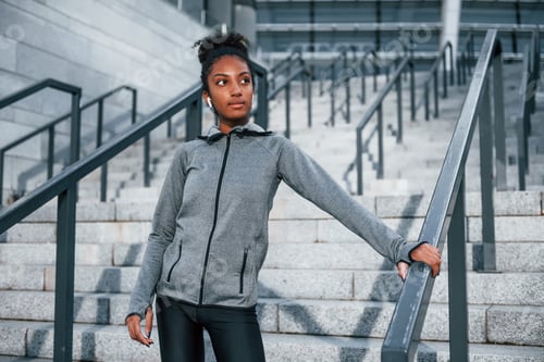 Preview: Young african american woman in sportive clothes have workout outdoors at daytime