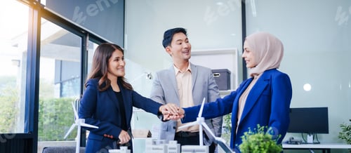 Preview: Three business people gather at a desk, unit with joined hands sustainable solutions for a cleaner