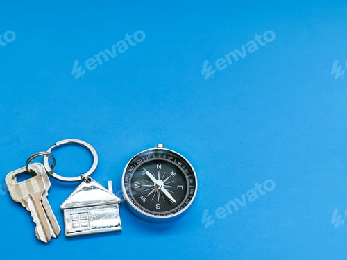Preview: House keys and compass isolated on blue background with copy space.
