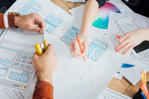 Preview: Cropped view of ux designers with stapler and marker planning app frameworks near smartphone on