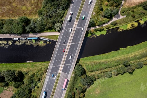 Preview: Aerial view directly above a busy UK motorway bridge over a river