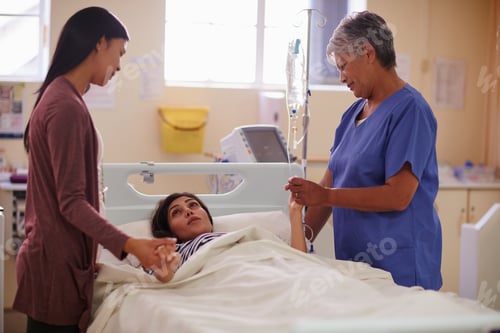 Preview: Shot of a patient lying in bed while her visitor and nurse comforts her