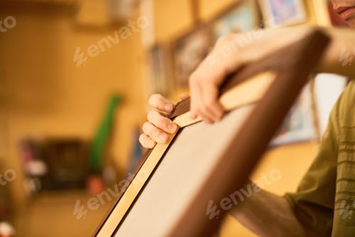Visualização: Man Framing Canvas in Art Studio with Focused Hands